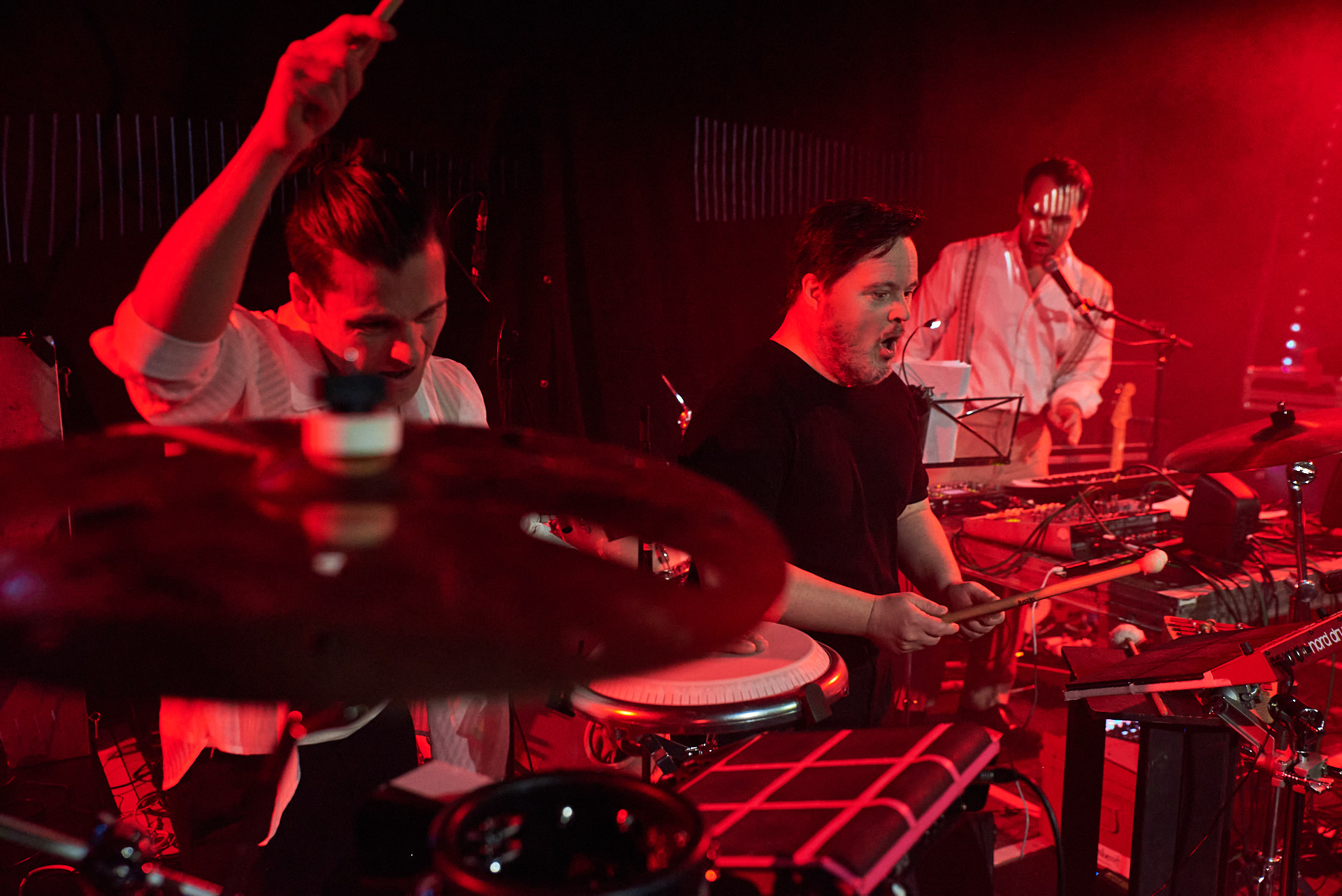 In rotes Licht gehüllt sieht man die zwei Percussionisten von 21 downbeat in Aktion an ihren Drummachines.